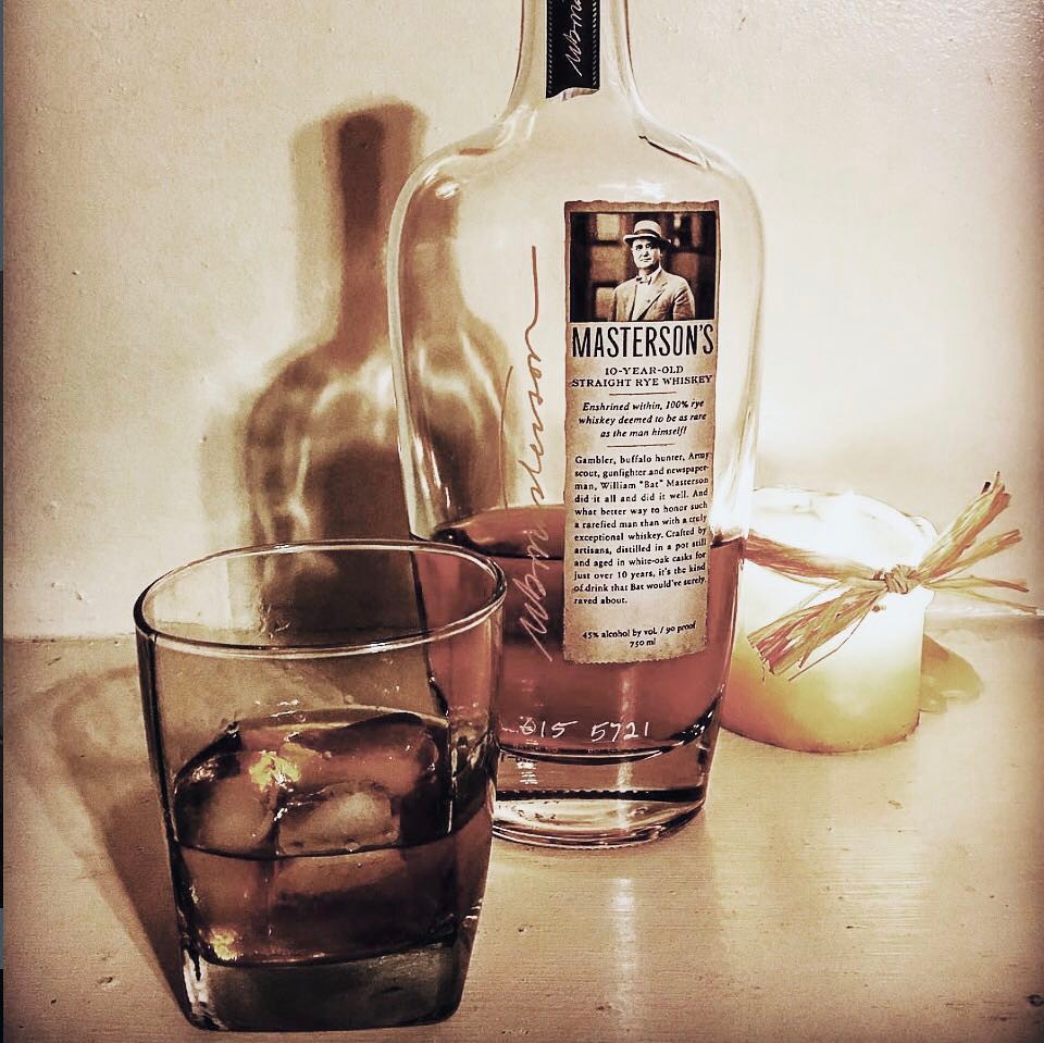Load image into Gallery viewer, Masterson's 10 Year Old Straight Rye whiskey bottle with a glass of ice on a wooden surface.