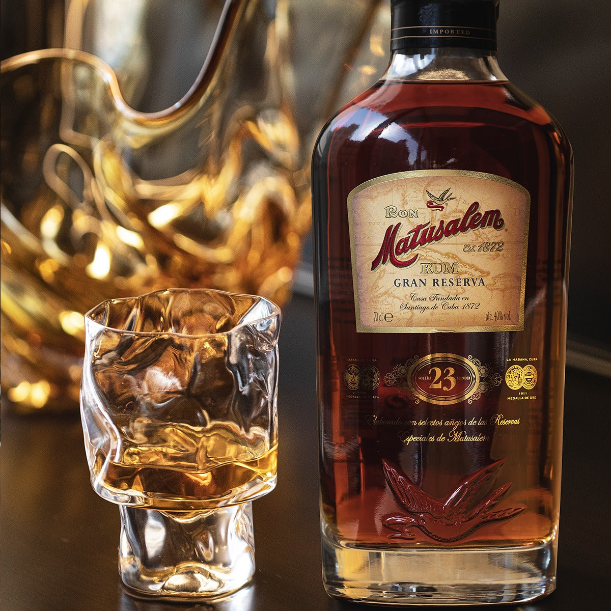 Load image into Gallery viewer, Bottle of Ron Matusalem 23 year old Gran Reserva rum with a glass filled with the liquor on a dark background.