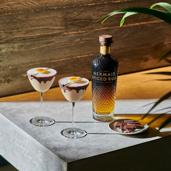 Load image into Gallery viewer, Mermaid Spiced Rum bottle with two cocktails on a stone surface