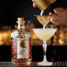 Load image into Gallery viewer, Bartender pouring a cocktail into a glass with a bottle of MeRSER DOUBLE BarreL RUM in the foreground.