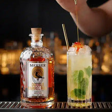 Load image into Gallery viewer, Bottle of Merser Double Barrel rum with a cocktail being prepared on a bar.