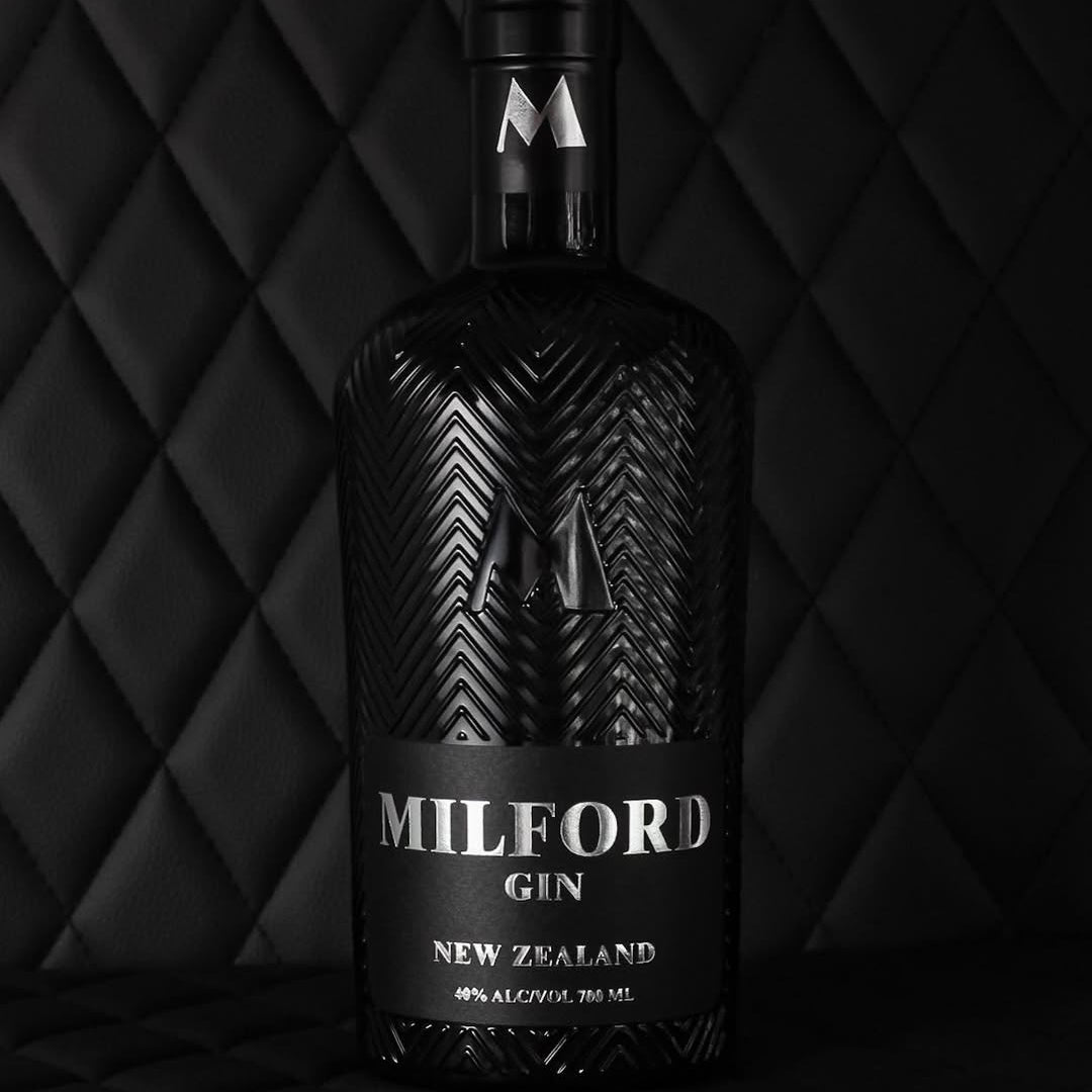 Load image into Gallery viewer, Bottle of Milford Gin against a black quilted background