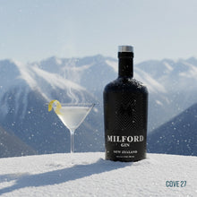 Load image into Gallery viewer, Bottle of Milford Gin with a cocktail in front of snow-covered mountains