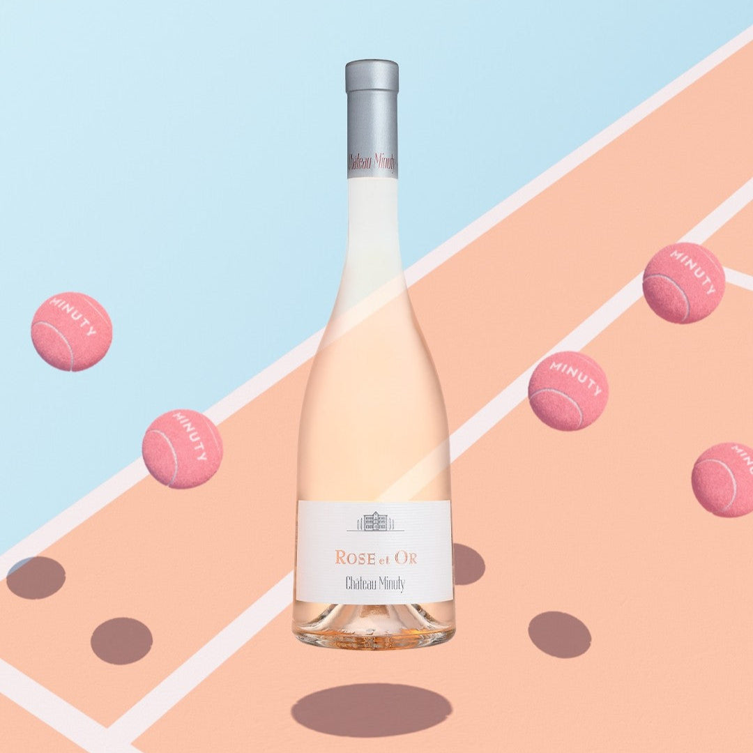 Load image into Gallery viewer, Bottle of Rose de Or wine on a colorful geometric background with pink tennis balls.