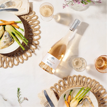 Load image into Gallery viewer, Table setting with wine bottle of Minuty Rose Et Or, plates of food, and glasses on a white surface.