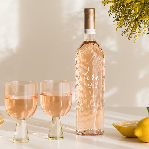 Load image into Gallery viewer, Bottle of Mirabeau Pure Provence Rosé wine with two glasses and lemons on a light surface.