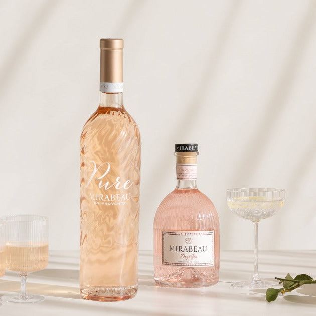Load image into Gallery viewer, Two bottles of Mirabeau, one wine and one gin, with glasses on a light background