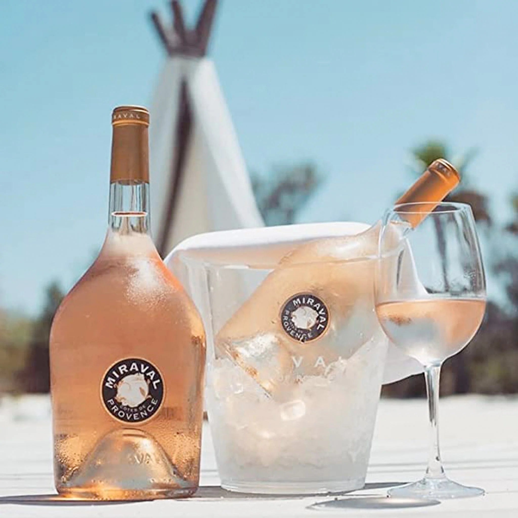 Load image into Gallery viewer, Maraval Provenèce rosé wine bottle with a glass and ice bucket against a blurred outdoor background.