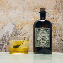Load image into Gallery viewer, Bottle of Monkey 47 gin with a cocktail on a textured surface
