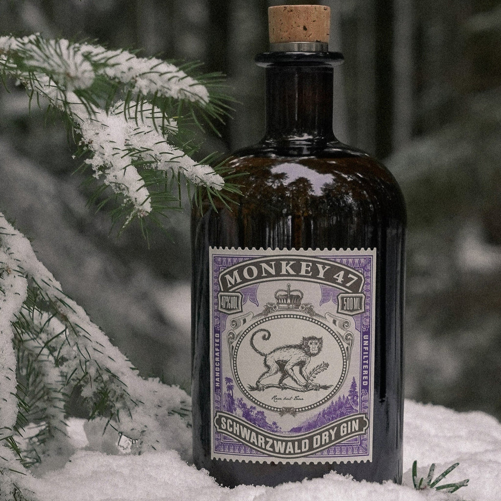 Bottle of Monkey 47 Schwarzwald Dry Gin in the snow with a blurred forest background