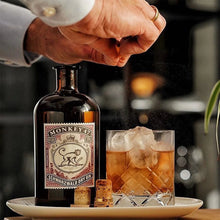 Load image into Gallery viewer, A man making a cocktail using a bottle of gin.