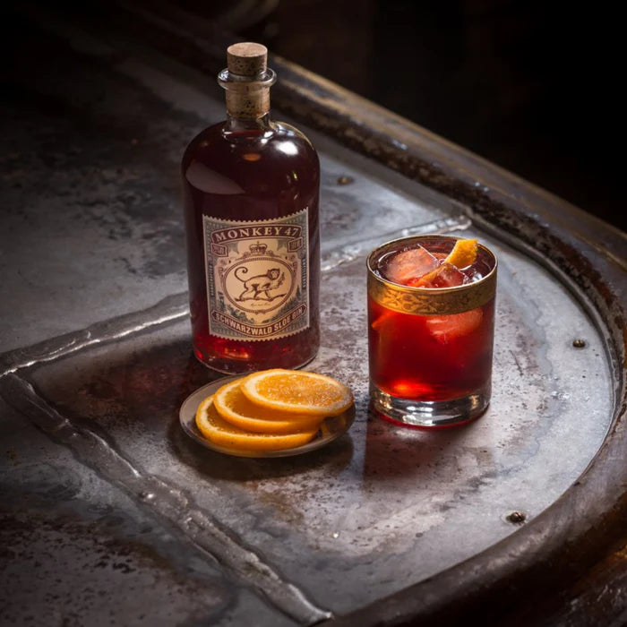 Bottle of Monkey 47 sloe gin with a cocktail on a metal tray
