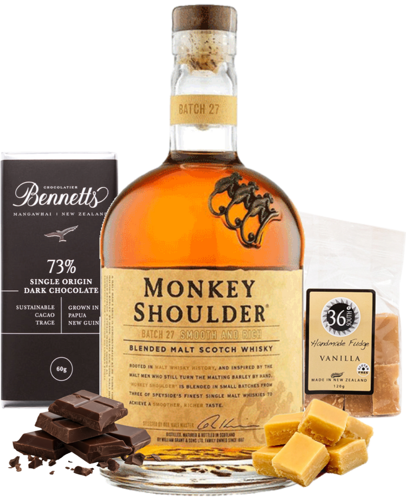 Bottle of Monkey Shoulder whisky with chocolate and fudge on a white background