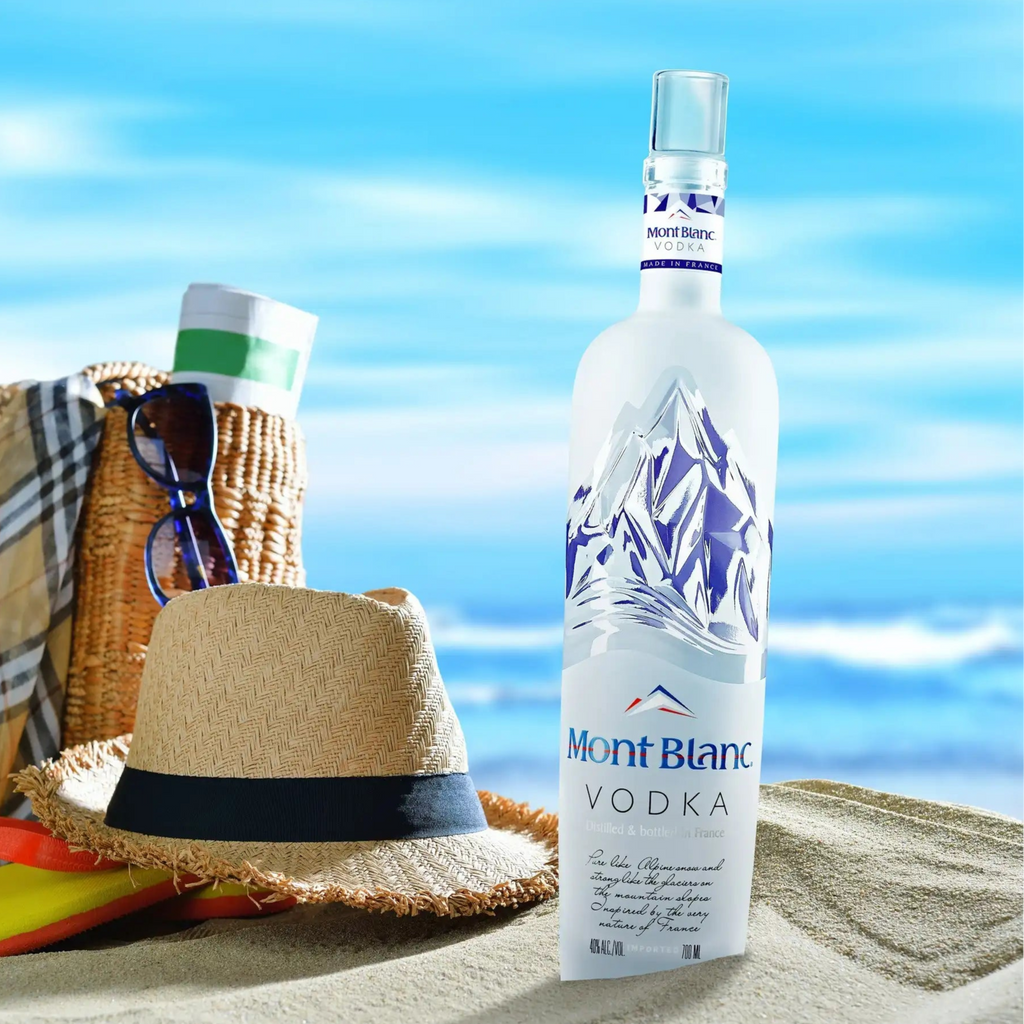 Mont Blanc Vodka bottle with beach accessories on a sandy background