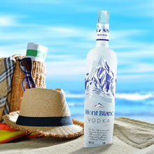 Load image into Gallery viewer, Mont Blanc Vodka bottle with beach accessories on a sandy background
