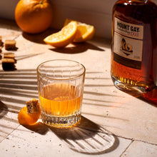 Load image into Gallery viewer, Glass of Mount Gay rum with honey and oranges on a wooden surface