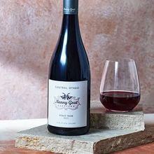 Load image into Gallery viewer, Bottle of Nanny Goat Vineyard Pinot Noir with a glass of wine on a stone surface.