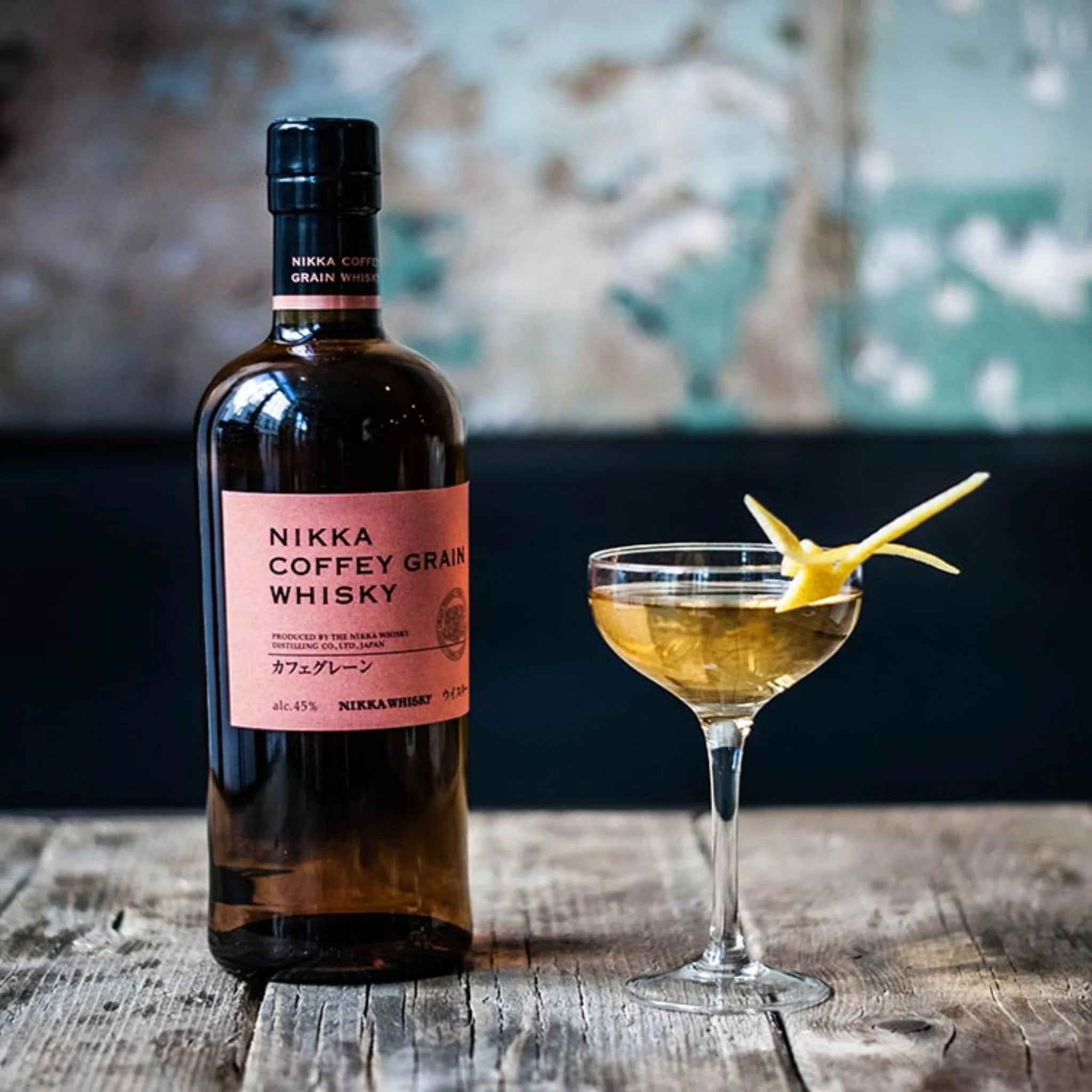 Load image into Gallery viewer, Nikka Coffey Grain Whisky on a wooden table with a cocktail 