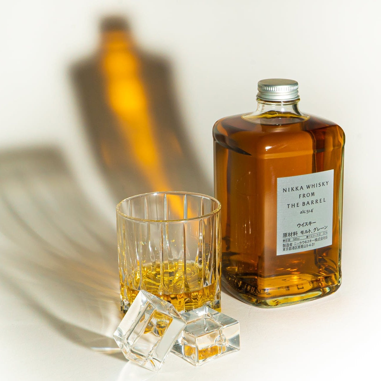 Load image into Gallery viewer, Whisky bottle and glass on a light background