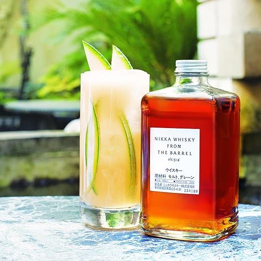 Load image into Gallery viewer, Nikka, The Barrel Japanese Whisky with a cocktail in a highball glass with a green garden in the background