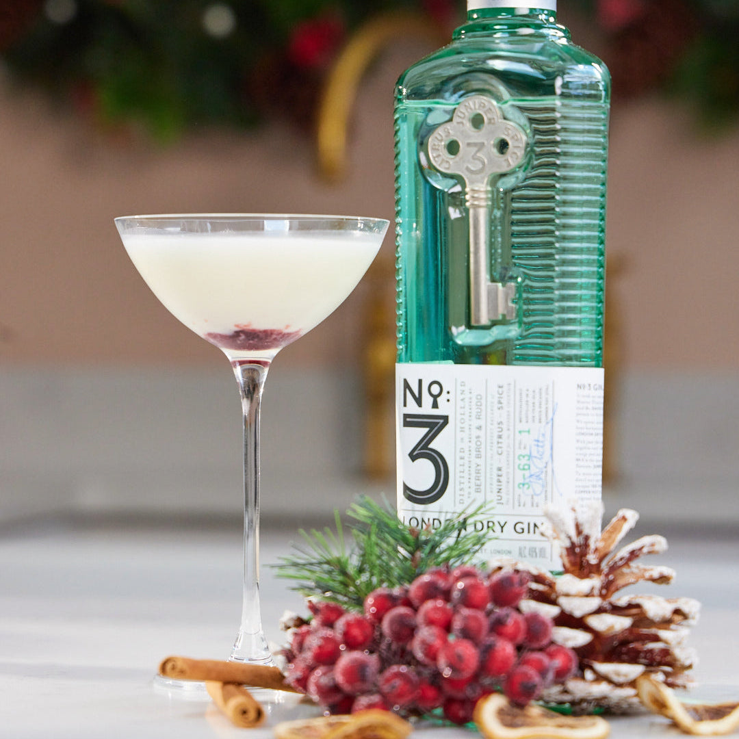 Load image into Gallery viewer, Bottle of No. 3 London Dry Gin with a cocktail and festive decorations on a table.