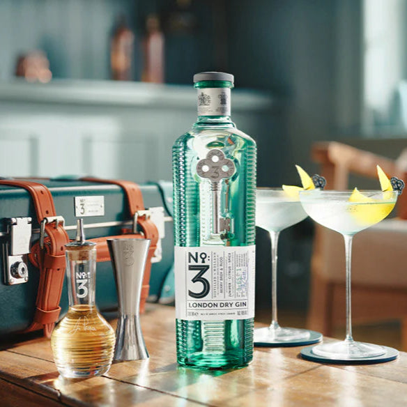 Bottle of No. 3 London Dry Gin with cocktail ingredients on a table.