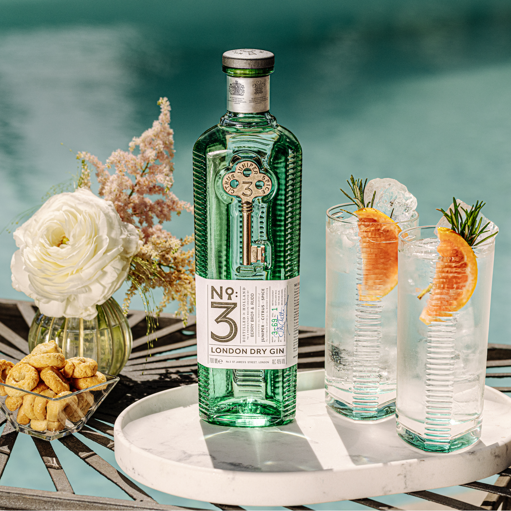 Load image into Gallery viewer, Bottle of No. 3 London Dry Gin with two cocktails on a table by a pool