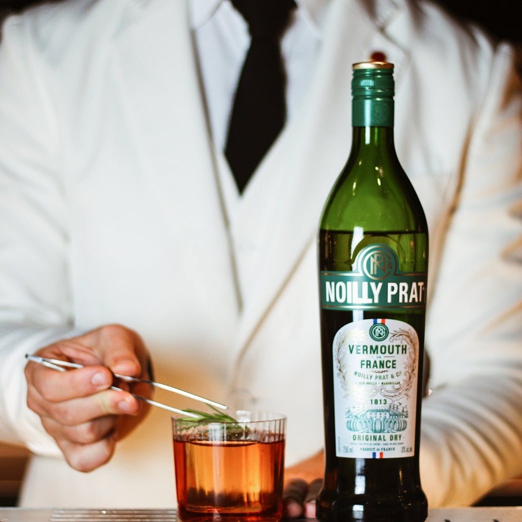Load image into Gallery viewer, A man mixing a cocktail with Noilly Prat Original Dry Vermouth