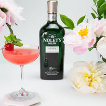 Load image into Gallery viewer, A bottle of gin and a cocktail with a strawberry in it on a white background with some flowers around it.