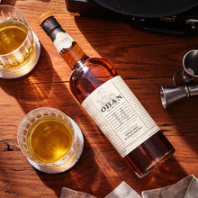Load image into Gallery viewer, Oban 14 year old whiskey bottle with two glasses on a wooden surface