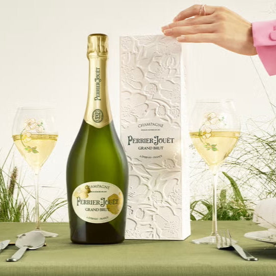 Load image into Gallery viewer, Bottle of champagne and packaging on a table with glasses.