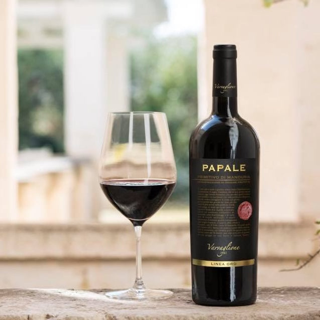Load image into Gallery viewer, A bottle of Papale Oro Varvaglione Primitivo di Manduria red wine next to a semi-filled red wine glass