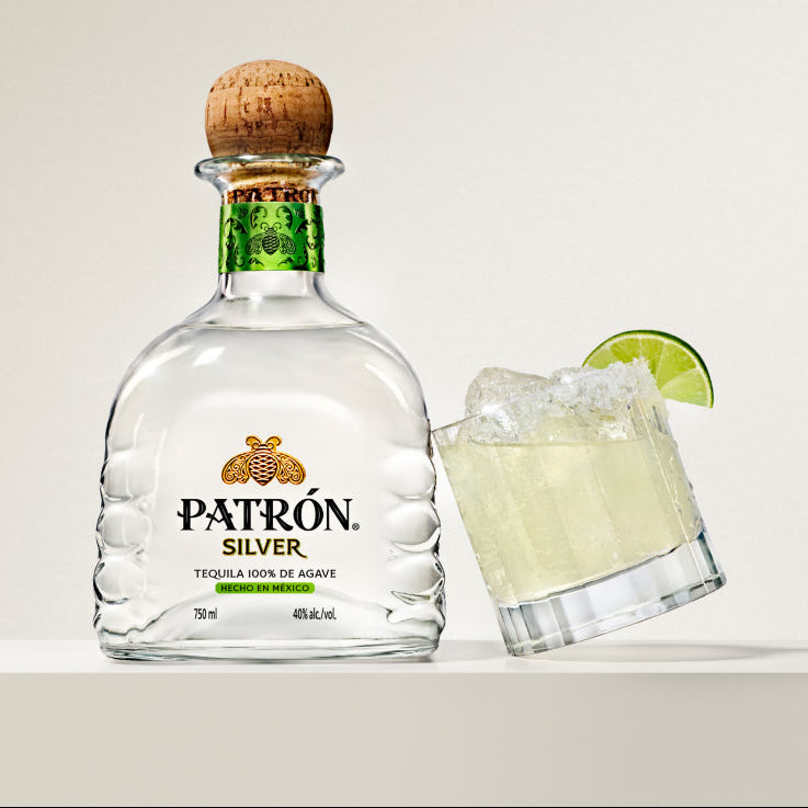 Load image into Gallery viewer, Patrón Silver tequila bottle with a glass of margarita on a white background