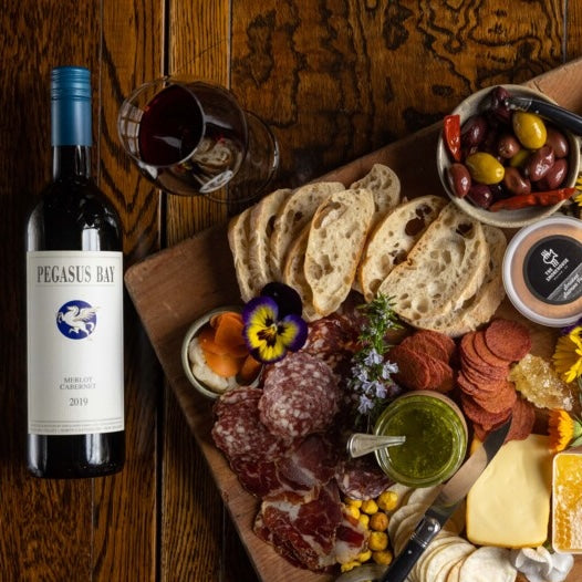 Load image into Gallery viewer, A bottle of Pegasus Bay merlot cabernet red blend wine next to a cheese and meat platter