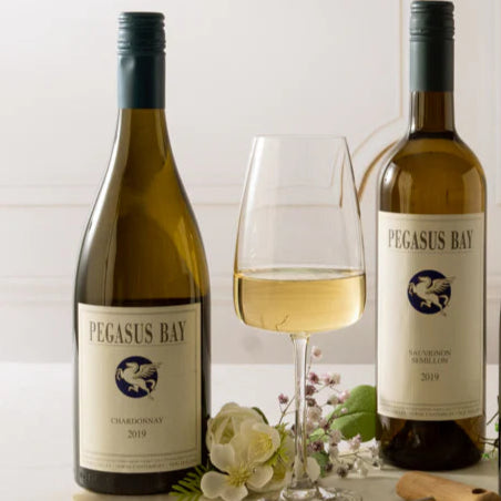 A bottle of Pegasus Bay wine on a marble tray with a glass of white wine.