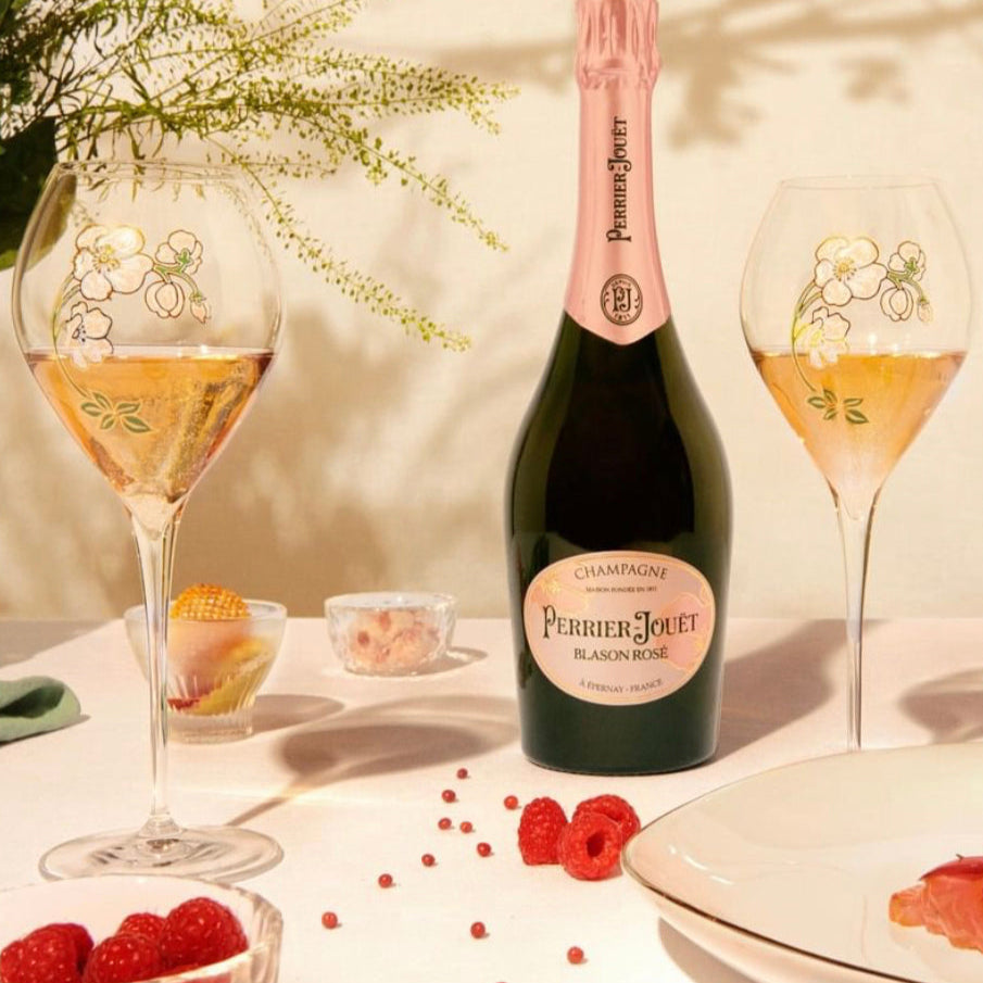 Load image into Gallery viewer, Bottle of Perrier-Jouët Blanc Rosé with two glasses and snacks on a table.