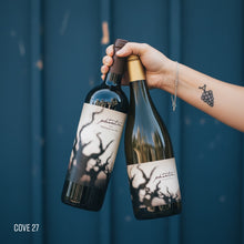 Load image into Gallery viewer, Two Bogle Phantom wine bottles, one red blend and one chardonnay, held by a woman's hand against a blue background