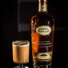 Load image into Gallery viewer, Bottle of Pierre Ferrand Cognac with a glass of cognac on a dark background