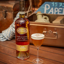 Load image into Gallery viewer, Bottle of Pierre Ferrand Cognac with a glass of cocktail on a wooden surface.