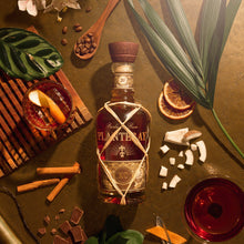 Load image into Gallery viewer, A bottle of rum in a table surrounded by chocolate, coffee beans, coconut etc