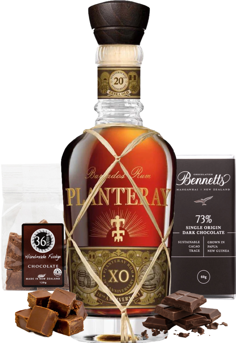 Load image into Gallery viewer, A bottle of Planteray XO rum centered on a white background, surrounded by chocolate products: a bag of 36 Handmade Fudge chocolate, a box of Bennett 73% single origin dark chocolate, and several chocolate pieces and chunks.