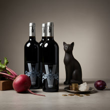 Load image into Gallery viewer, Three bottles of Poderi Crisci Viburno red wine with a decorative cat figure and fruit on a neutral background