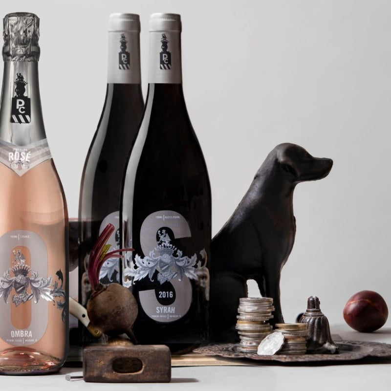 Load image into Gallery viewer, Three wine bottles with decorative elements on a table