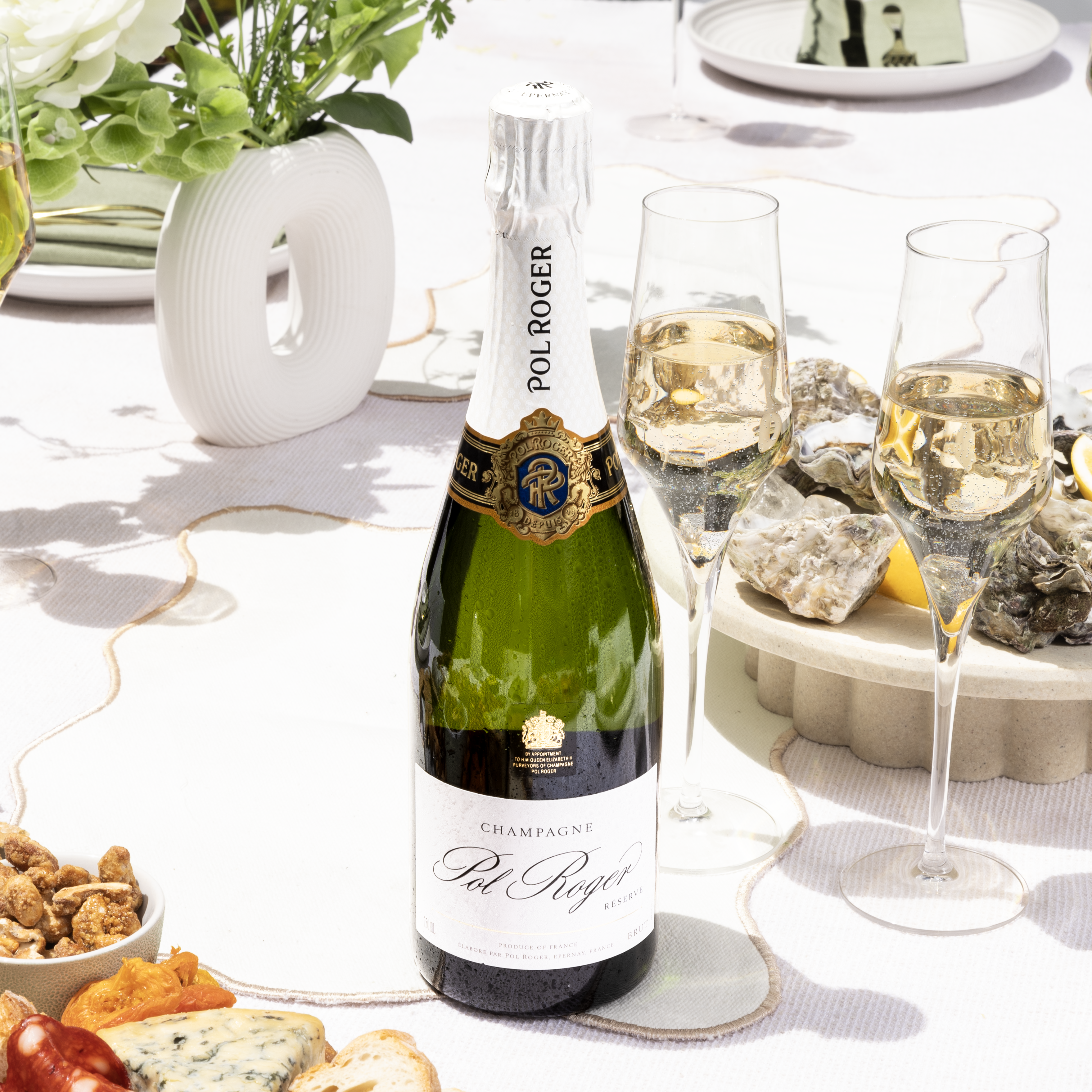 Load image into Gallery viewer, A bottle of champagne on a white table with some oysters