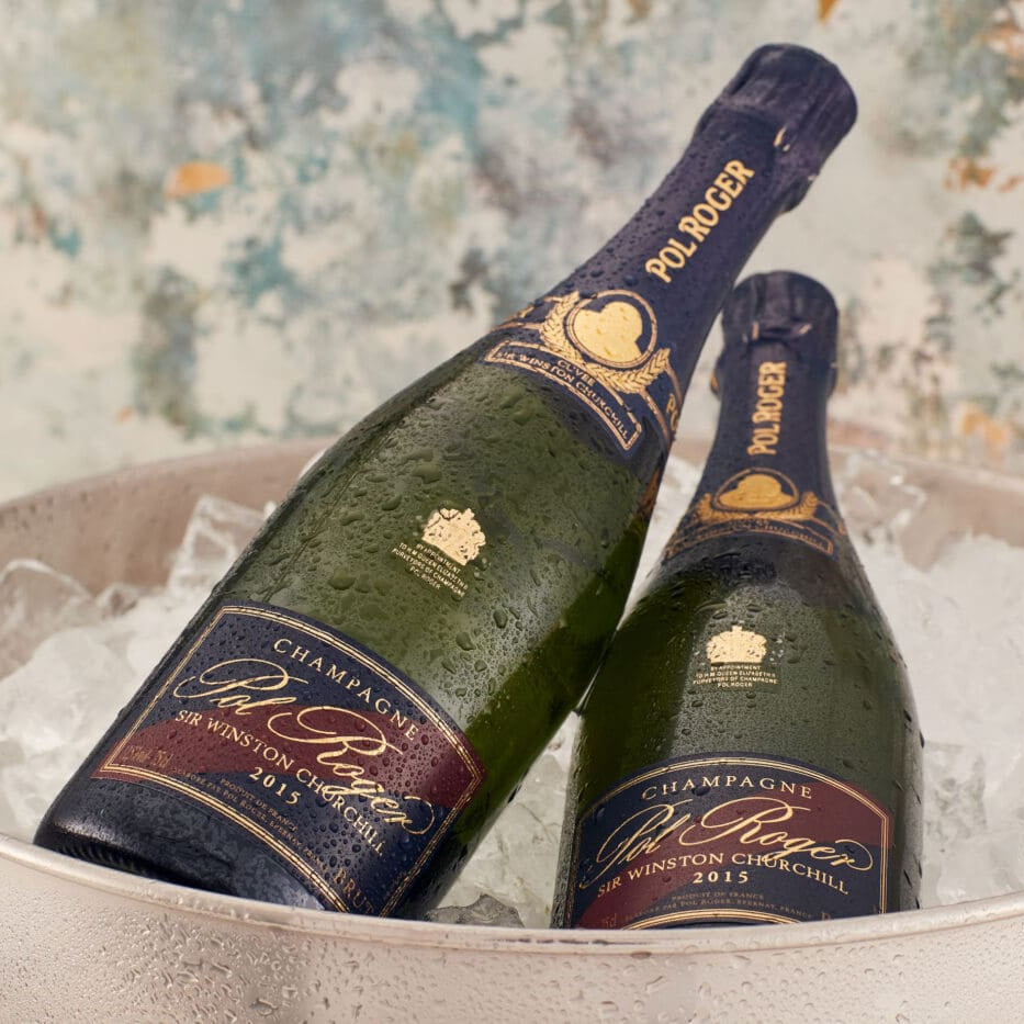 Load image into Gallery viewer, Two bottles of POL ROGER Cuvée Sir Winston Churchill Champagne in a bucket of ice with a floral background.
