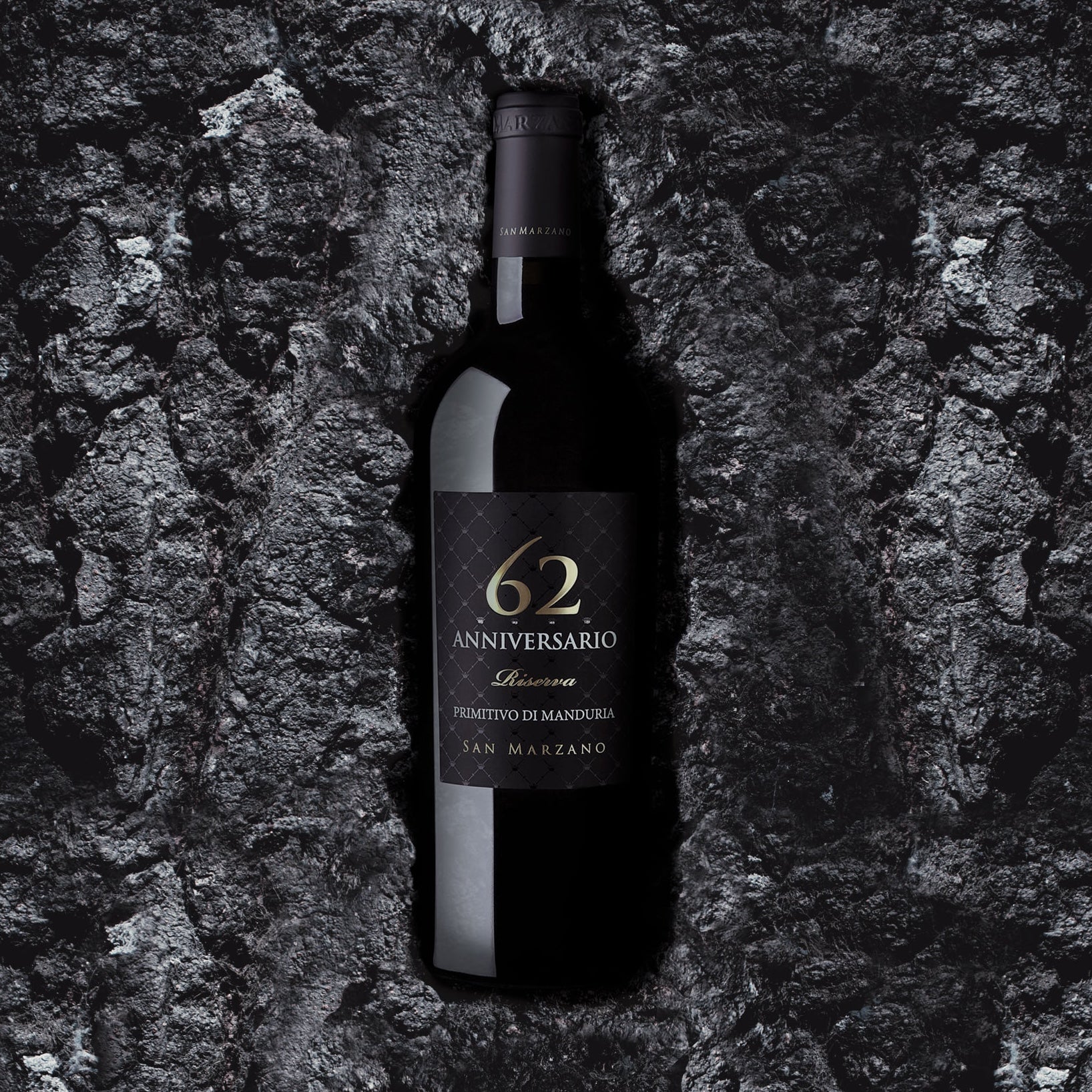 Load image into Gallery viewer, A bottle of Primitivo di Manduria Riserva Anniversario 62 San Marzano lying on granite rock