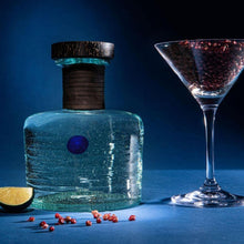 Load image into Gallery viewer, Procera Blue Dot Kenyan Gin bottle with a cork, lime wedge, and cocktail glass on a dark blue background