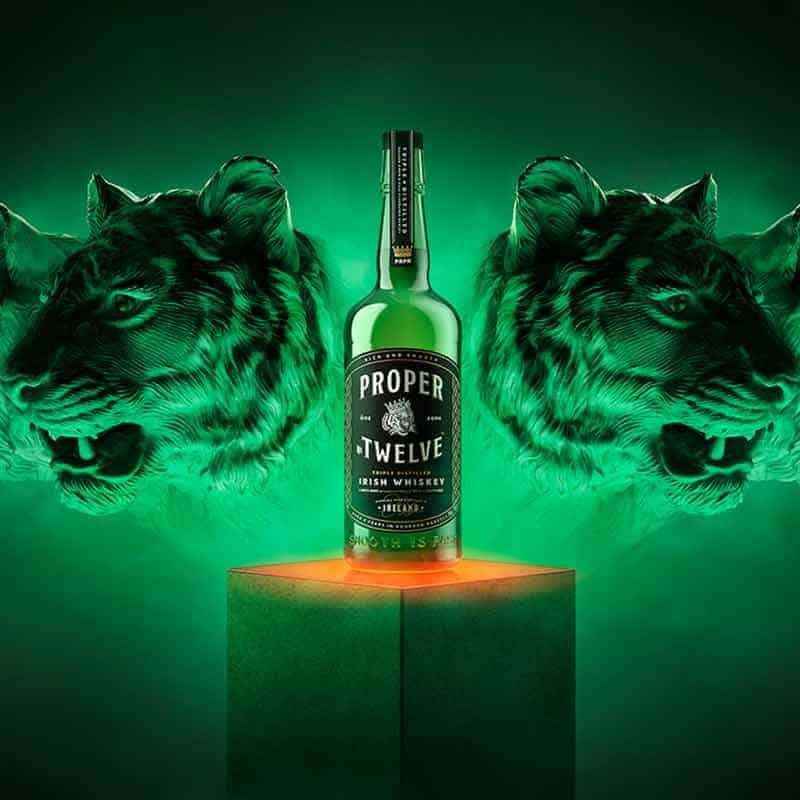 A bottle of Proper Twelve Irish Whiskey  with a green background with tigers on it