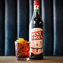Load image into Gallery viewer, Bottle of Punt e Mes with a cocktail on a dark background
