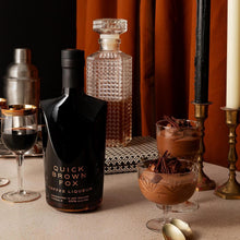 Load image into Gallery viewer, A bottle of Quick Brown Fox Coffee liqueur and chocolate mousse and a drink on a table with a nice setting with lit candles